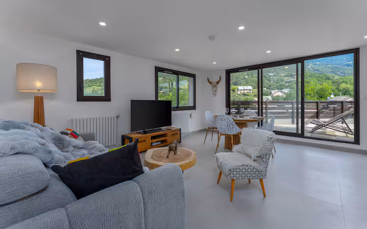 Le salon chaleureux avec TV connectée et canapé convertible