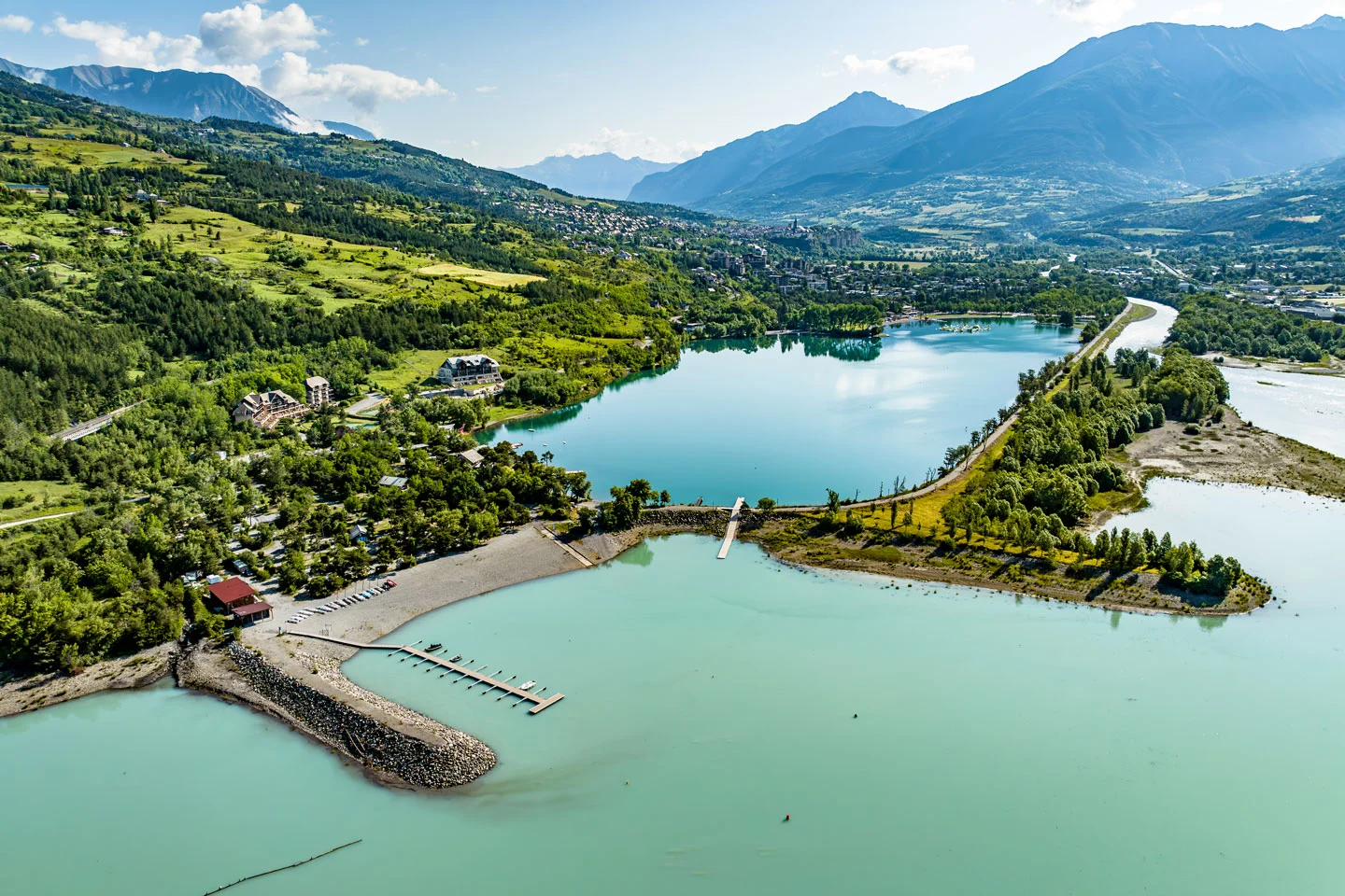 Vue aérienne du lac de Serre-Ponçon avec sa marina et les sommets des Hautes-Alpes en arrière-plan